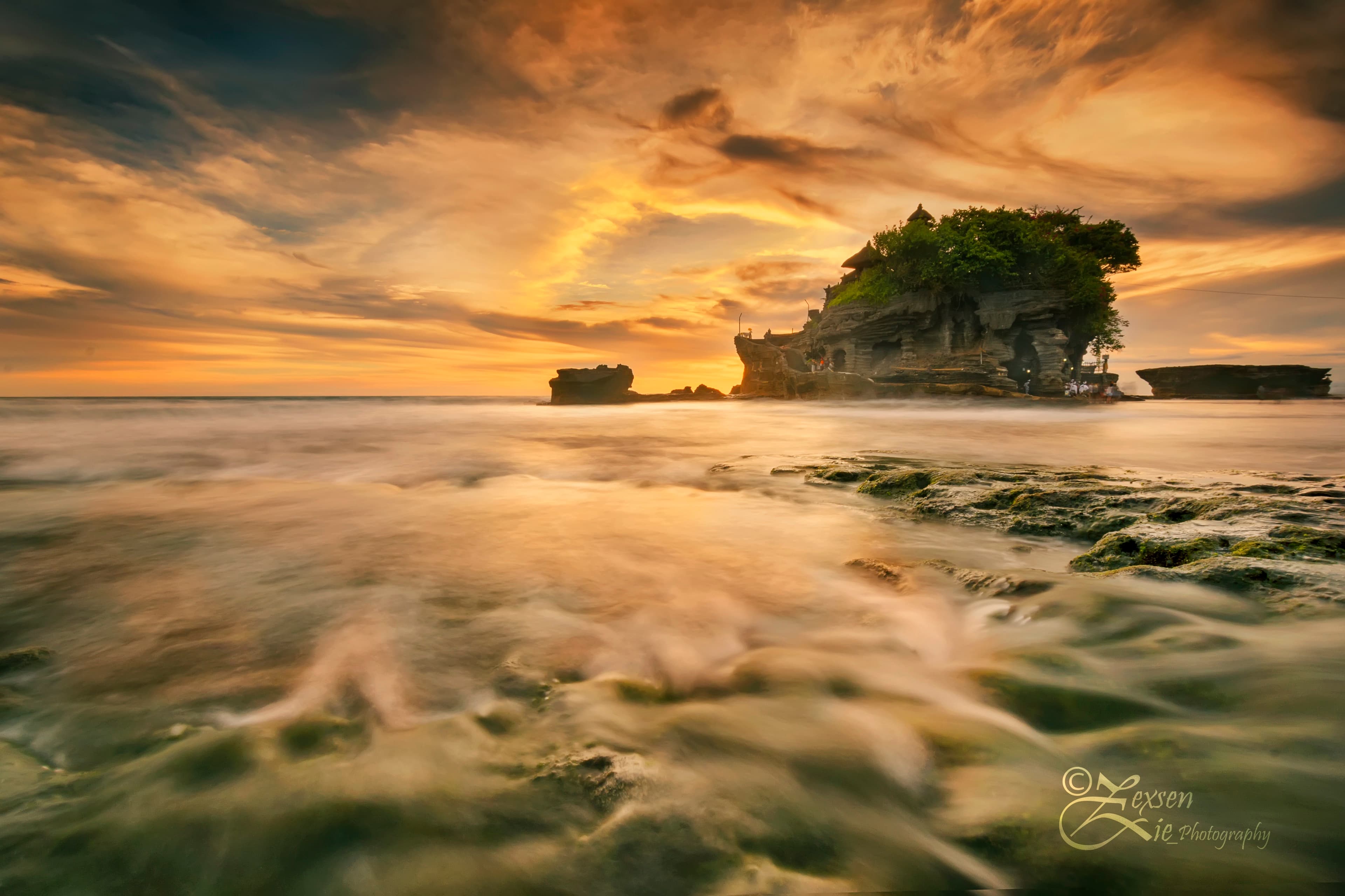 A coastline silhouetted against a golden sunset