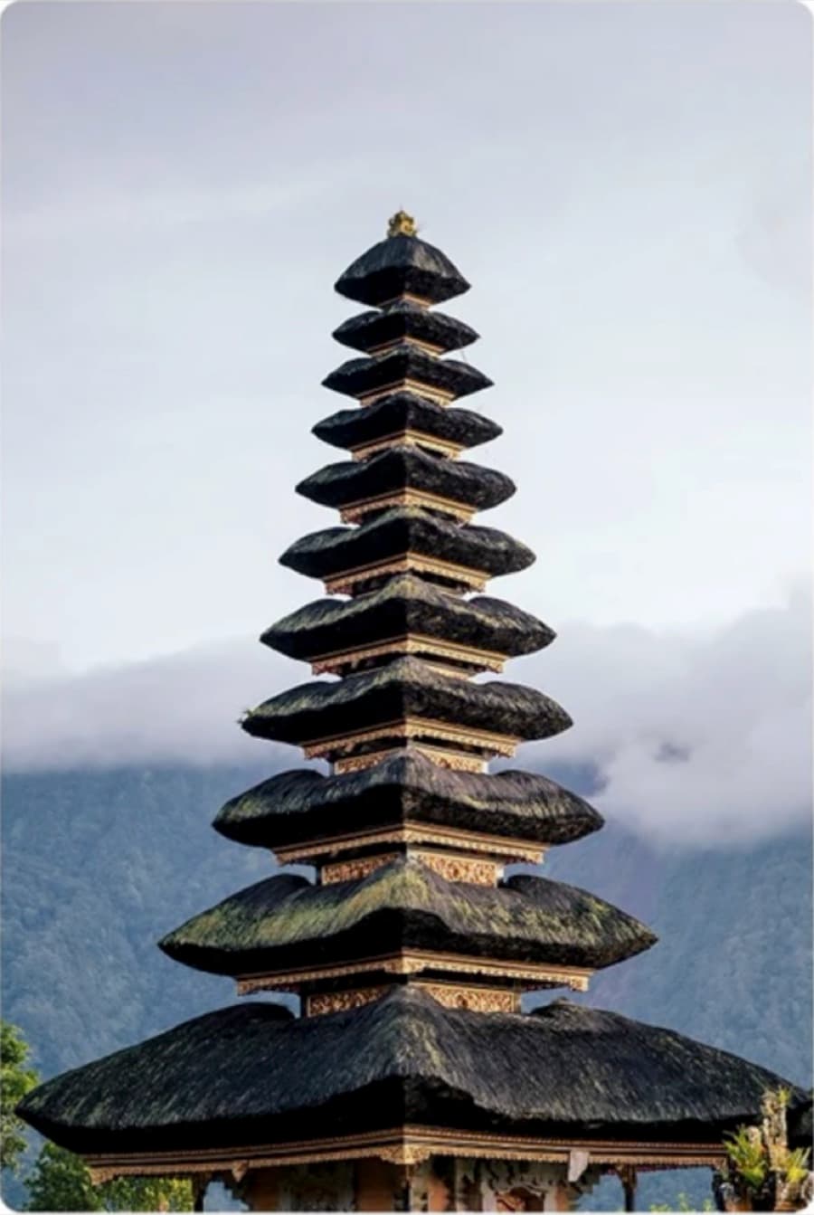 A tiered temple against a misty mountain